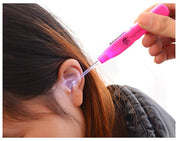 LED ear cleaner being used on a person's ear, showing the bright pink tool with illumination