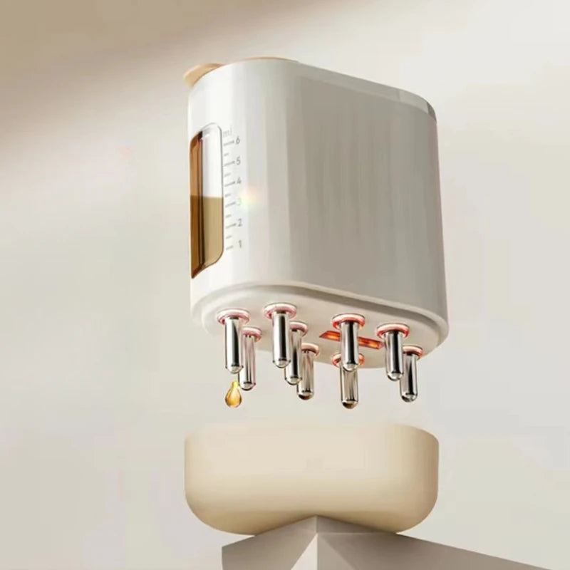 EMS Scalp Massager with eight nozzles dispensing golden liquid, mounted on cream-colored base