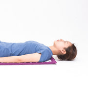 Blue acupressure mat with matching cylindrical pillow displayed flat showing full point coverage
