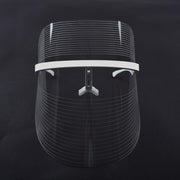 Front-facing view of LED photon facial mask showing illuminated light grid pattern against dark background