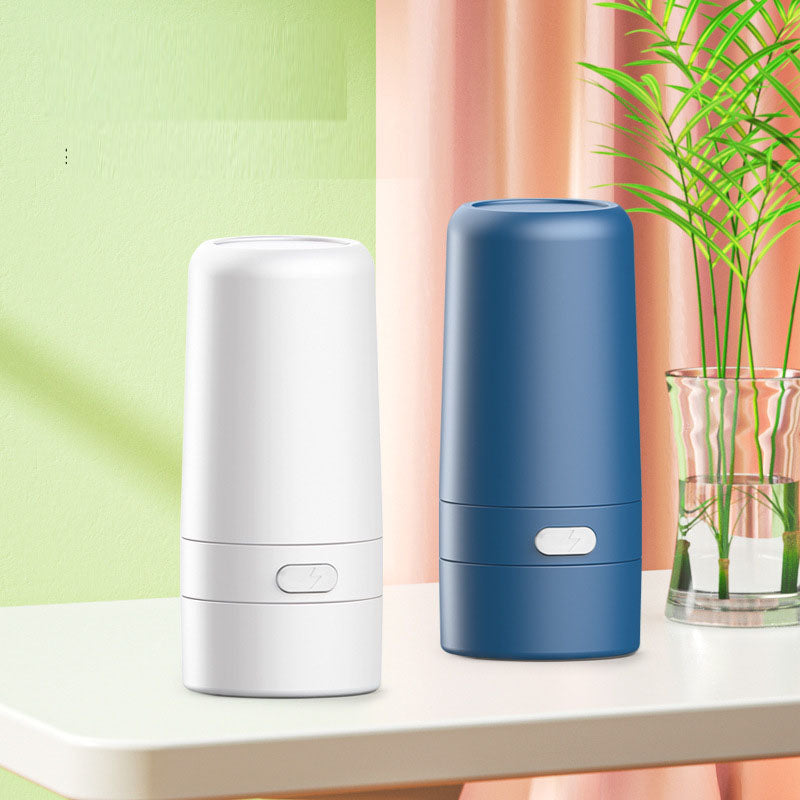 Two units (white and blue) displayed on white surface beside potted plant with colorful green and coral background