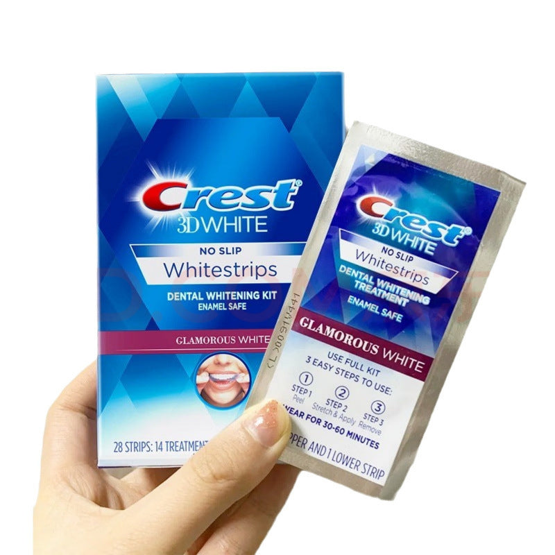 Hand holding Crest 3D White No Slip Whitestrips box and open sachet showing product