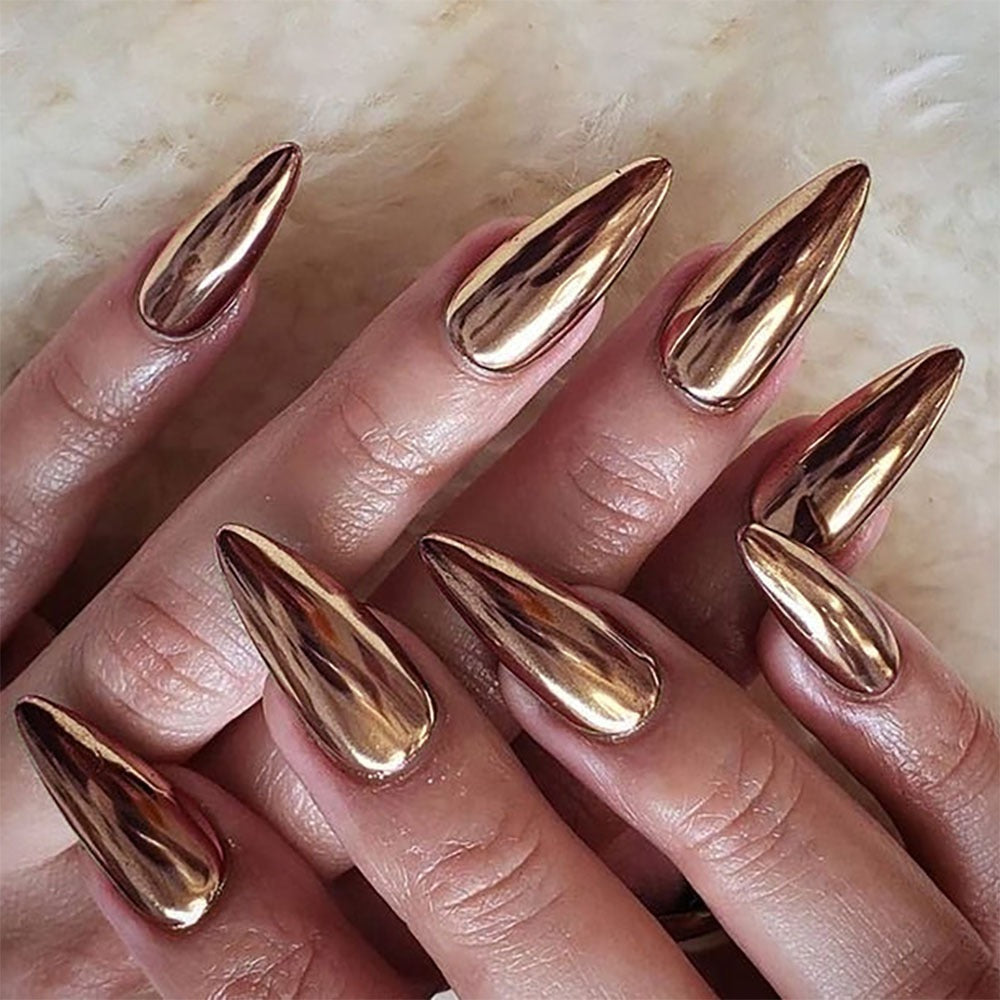 Close-up of press-on nails on hand showing rose gold and bronze metallic chrome almond shapes with mirror effect