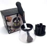 Complete makeup brush cleaning system unboxed showing electric device with handle, clear basin, spinner basket, and storage carousel