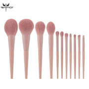All 11 Anmor pink makeup brushes arranged in a fan layout from largest to smallest on a white background
