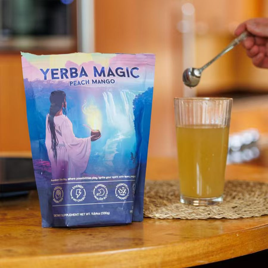 Yerba Magic Peach Mango powder pouch displayed on wooden surface next to prepared drink in glass with gold spoon