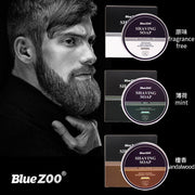 Well-groomed man with full beard shown in side profile, touching his face; brand logo and three product variants displayed with fragrance labels