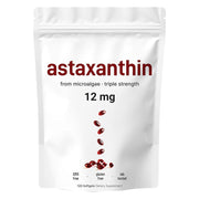 Front-facing product packaging: white resealable pouch with burgundy 'astaxanthin' headline, '12 mg' dosage, visible cascade of dark red softgel capsules, certifications (GMO free, gluten free, lab tested), '120 Softgels Dietary Supplement' tagline
