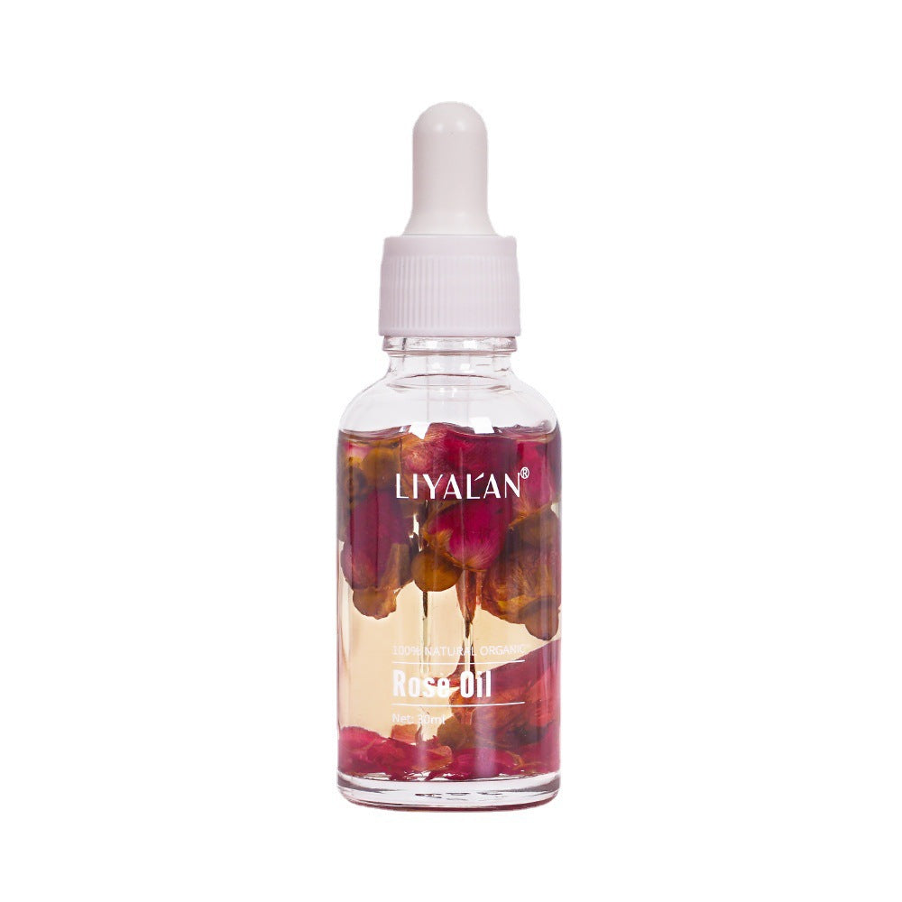 Single LIYALAN Rose Oil bottle on white background showing clear glass with white dropper cap and visible rose petals in burgundy and golden liquid