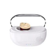 White magnetic charging case with cream and burgundy hearing aid device sitting in central dock, chrome handle visible