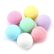Seven pastel-colored bath bombs arranged in a cluster on white background showing full color variety