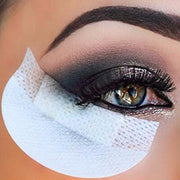 Close-up of eye with smokey gray eyeshadow and bright white eye shadow shield protecting under-eye area