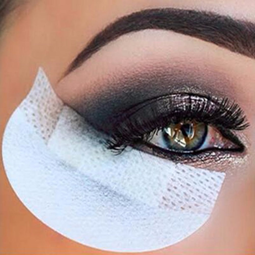 Close-up of eye with smokey gray eyeshadow and bright white eye shadow shield protecting under-eye area