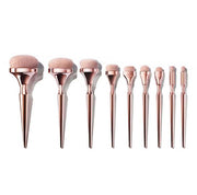 All 9 rose gold makeup brushes arranged by size from largest to smallest on white background