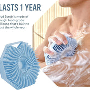 Person using blue silicone body scrubber on wet skin with soap lather, demonstrating ergonomic grip and lather generation