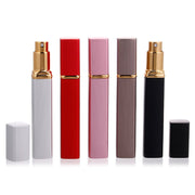 Five refillable perfume atomizers in silver, red, pink, taupe, and black displayed side by side with caps removed showing gold spray heads