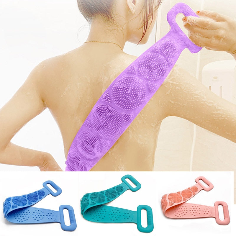 Woman using purple silicone scrubber belt on back in shower with water and soap visible