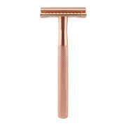 Rose gold double-edge safety razor with textured grip handle on white background