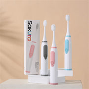 Three electric toothbrush models displayed with packaging box against neutral beige background