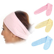 Woman wearing a pink spa headband shown in profile alongside three headbands in pink, yellow, and blue laid flat