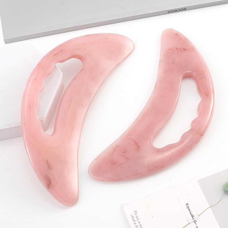 Two gua sha boards laid flat showing front and back/side profiles side by side in pink marble resin