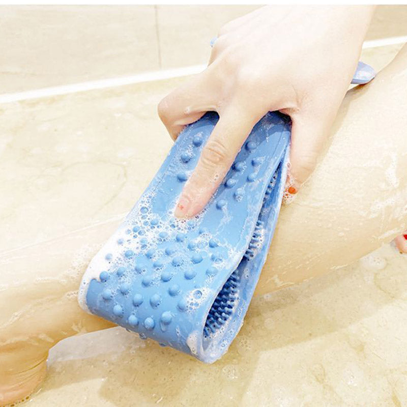 Close-up of blue scrubber in use on woman's back with visible water and lather during shower