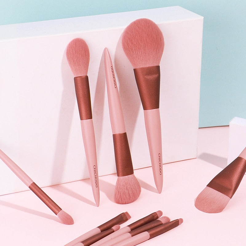 Close-up of multiple brushes with different sizes and shapes arranged against white box packaging