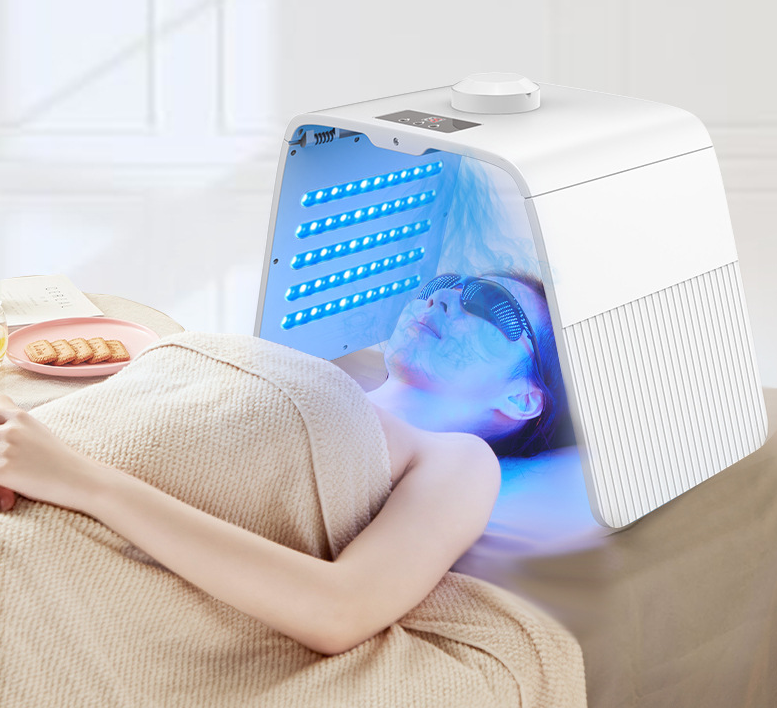 Woman using device with bright blue LED light therapy visible on face, seated comfortably at home with casual lifestyle setting