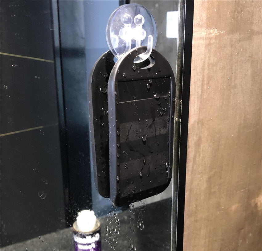 Black sharpener mounted on wall with suction cup, water droplets visible on surface