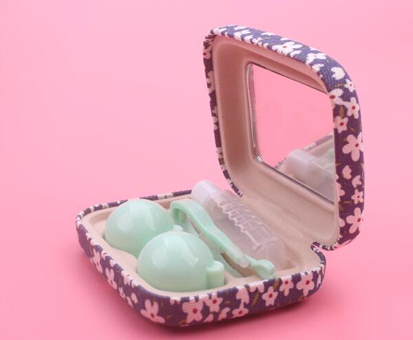 Pink floral case open on pink background with cream false eyelashes and white tool visible in cushioned slots