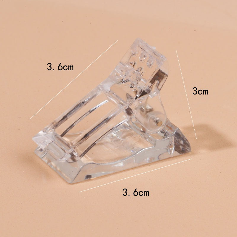 Rear angled view of the transparent nail clip showing the metal spring hinge mechanism and geometric base structure