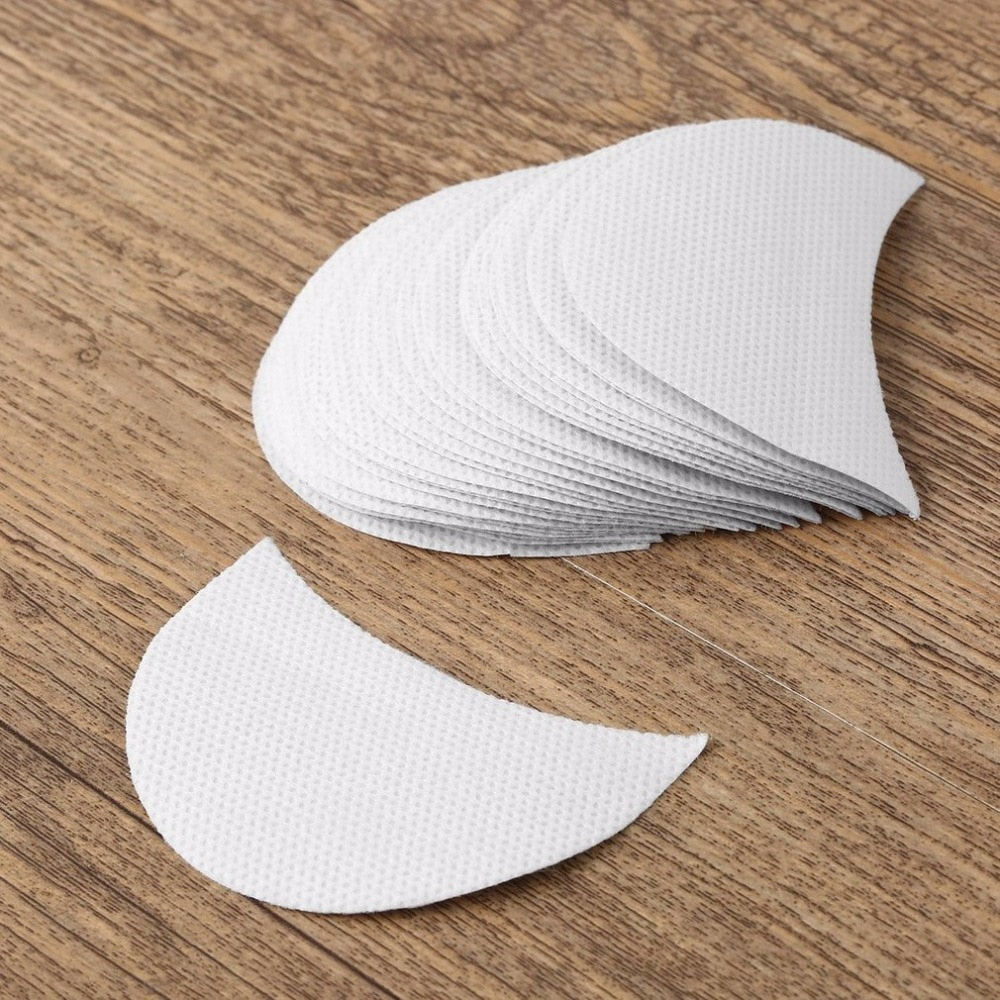 Overhead shot of stacked white cotton shields on wooden surface showing curved contour and layered stack