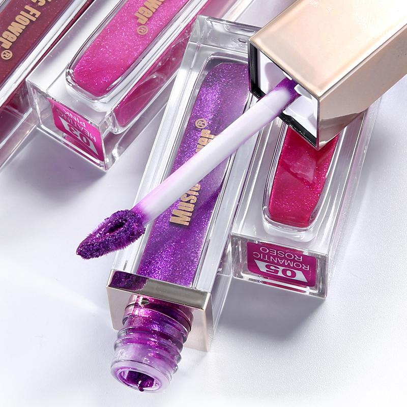 Close-up of multiple Metallic Lip Luminizer tubes in vibrant shades including magenta, purple, and burgundy with visible glitter particles and precision applicator wands