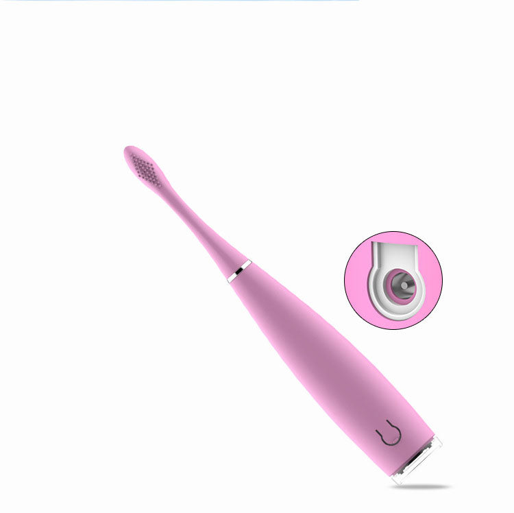 Pink and black toothbrushes standing in clear holder on bathroom counter next to sink
