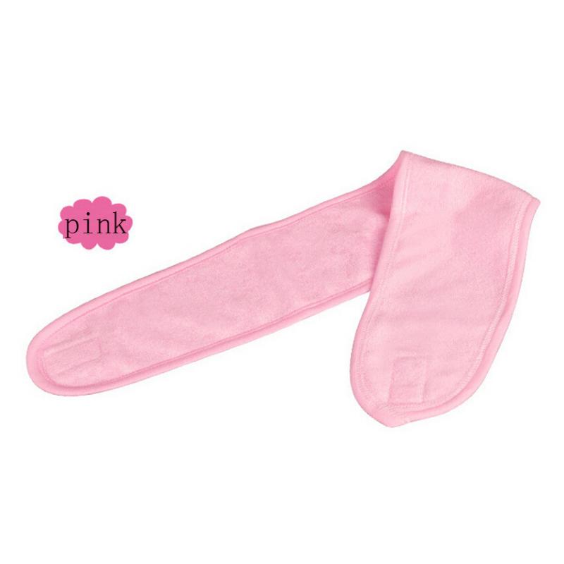 Close-up of hands fastening the pink headband at the back of the head