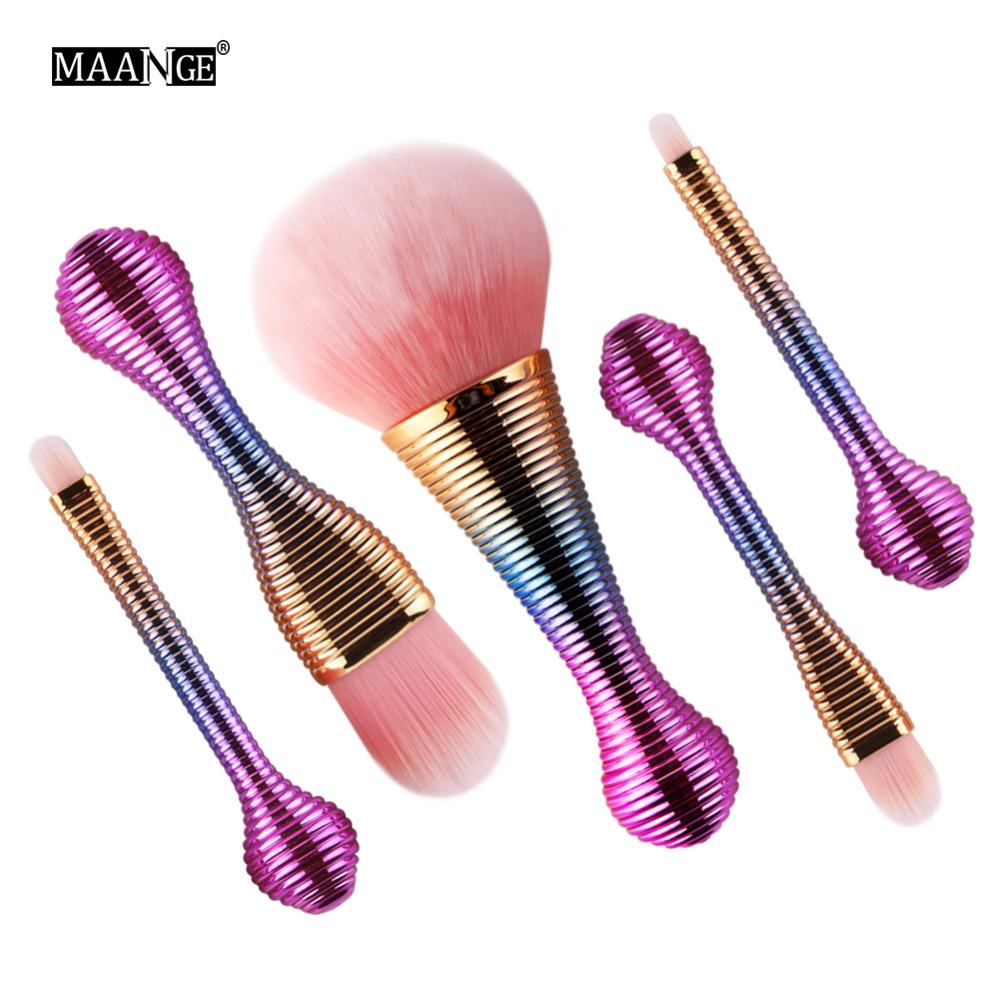 Five MAANGE brushes with iridescent purple-to-blue gradient handles and gold ferrules, pink bristles, arranged dynamically