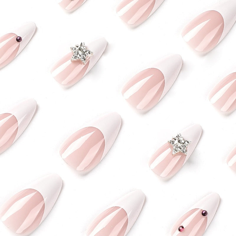 Flat lay grid of individual press-on nails showing gradient pink-to-white ombré with star and rhinestone variations