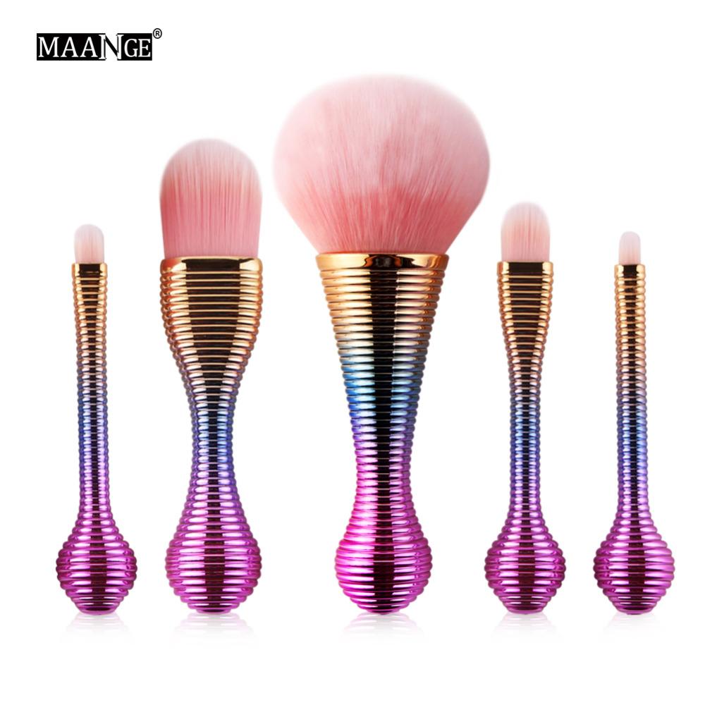 Five MAANGE brushes with purple-to-gold gradient ribbed handles and pink fluffy bristles on white background
