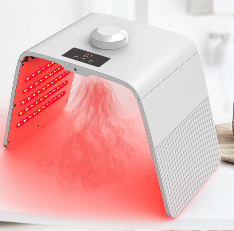 White device on home surface with coral-red LED light streaming downward, demonstrating active treatment mode