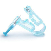Close-up of ear piercing gun mechanism held in hand showing transparent blue plastic housing with internal spring-loaded components and metal parts