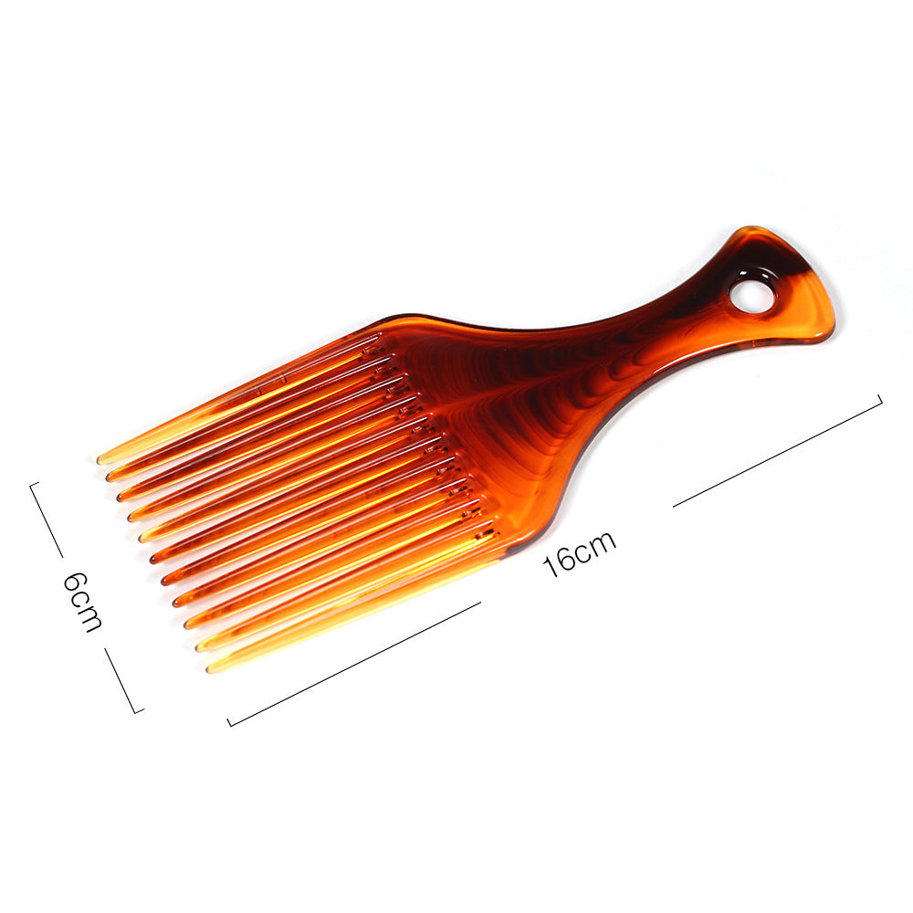 Hair pick comb leaning against its clear plastic storage box on a white background